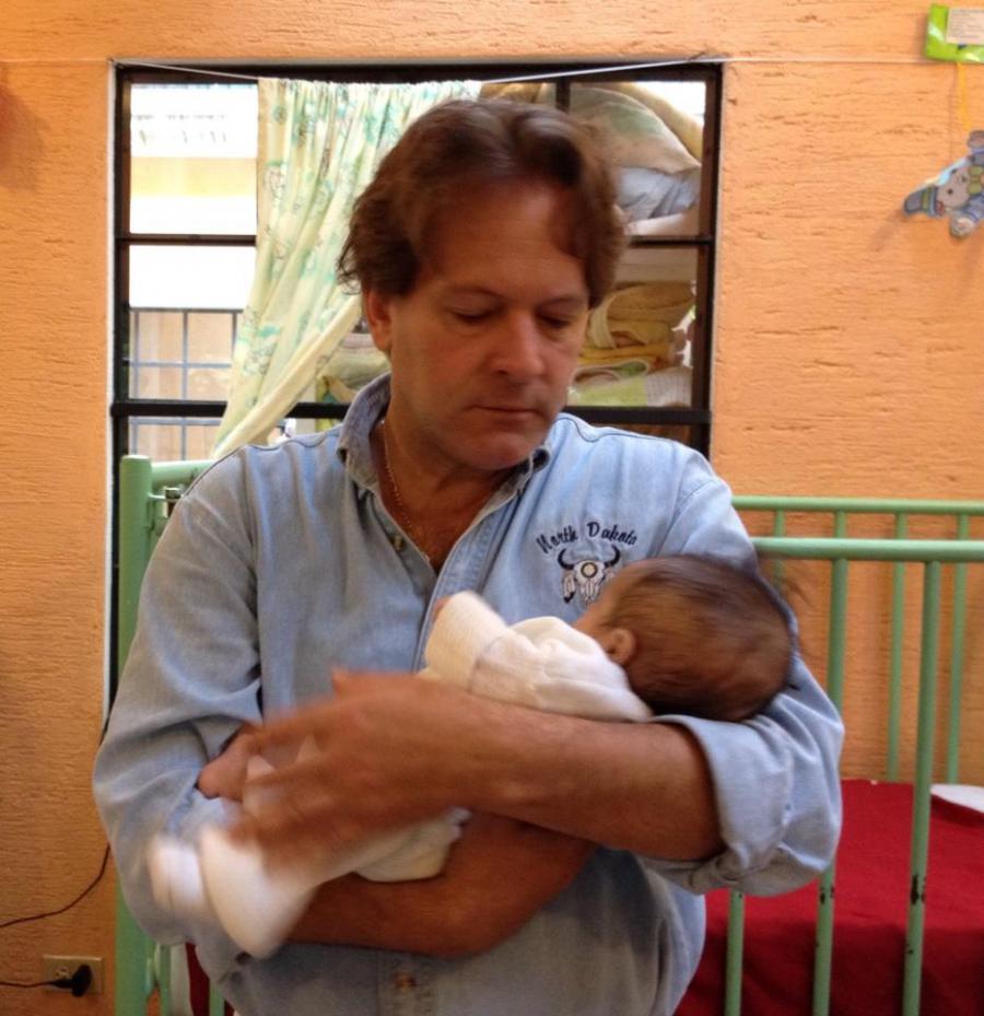 ITEMP founder and CEO Patrick Atkinson cuddles a rescued infant at the programs clinic for malnourished infants