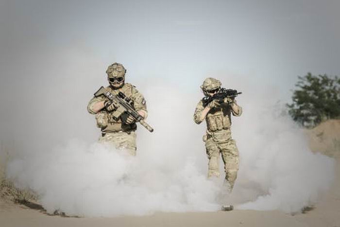 Soldiers with guns in the desert during a war